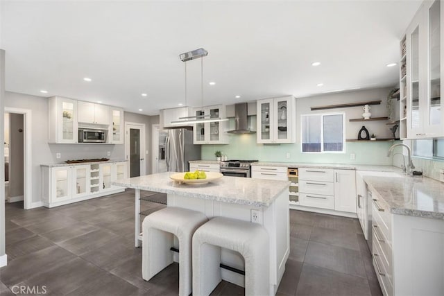 26925 Calle Dolores, Dana Point, CA 92624 - kitchen featuring stainless steel appliances, wall chimney range hood, a sink, a kitchen island, and white cabinets