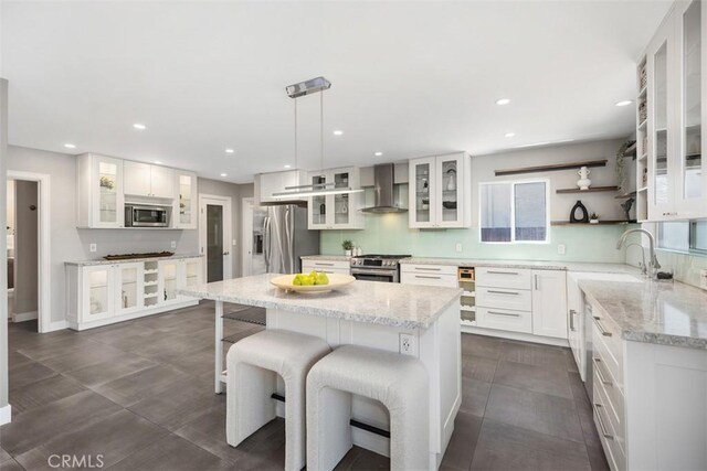26925 Calle Dolores, Dana Point, CA 92624 - kitchen with appliances with stainless steel finishes, wall chimney exhaust hood, a kitchen island, white cabinetry, and recessed lighting