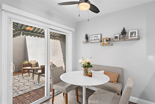 dining space with ceiling fan, baseboards, and wood finished floors