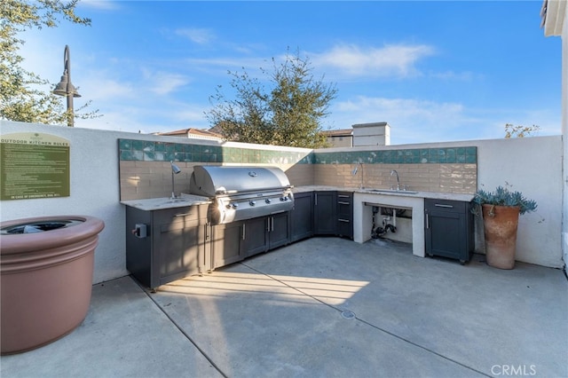 view of patio / terrace featuring an outdoor kitchen, a sink, grilling area, and fence