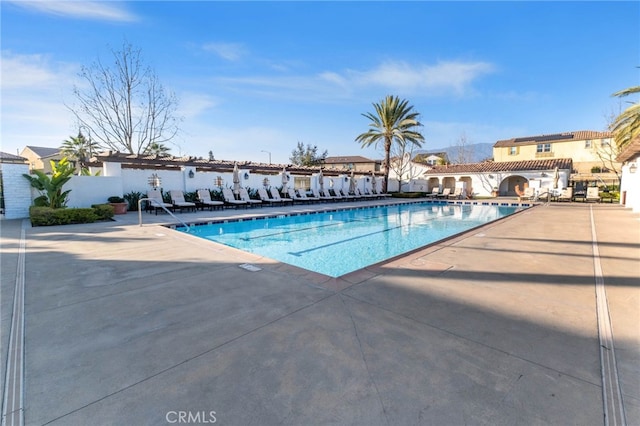 community pool featuring a patio area and fence