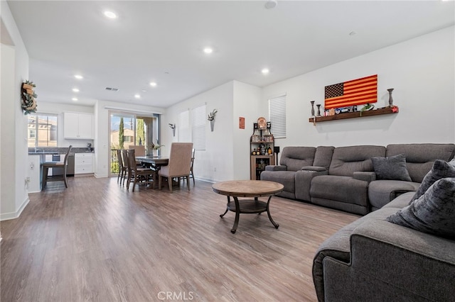 living room featuring visible vents, light wood-style flooring, baseboards, and recessed lighting