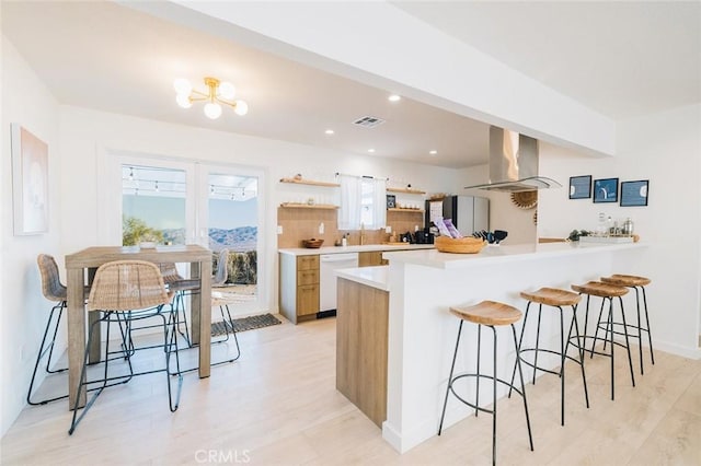 4883 Avenida La Candela, Joshua Tree, CA 92252 - kitchen featuring ventilation hood, white dishwasher, open shelves, a breakfast bar, and light wood-style floors