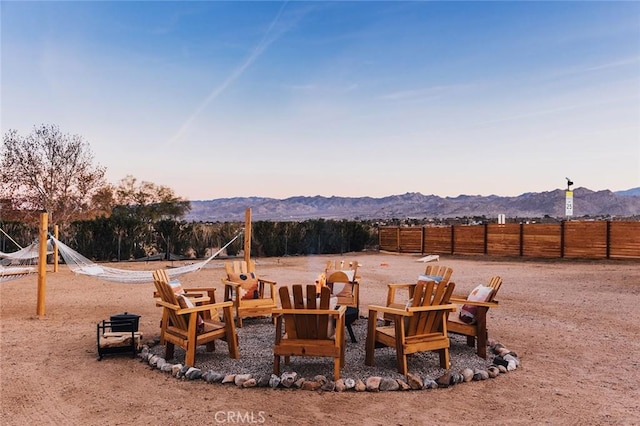 4883 Avenida La Candela, Joshua Tree, CA 92252 - playground at dusk featuring a mountain view and an outdoor fire pit