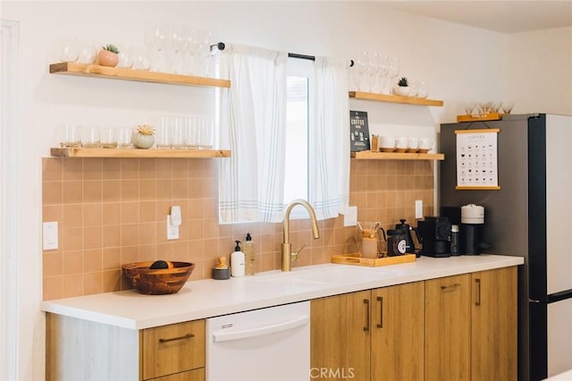 4883 Avenida La Candela, Joshua Tree, CA 92252 - kitchen with open shelves, dishwasher, backsplash, brown cabinetry, and light countertops