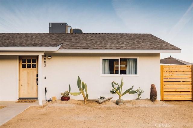 4883 Avenida La Candela, Joshua Tree, CA 92252 - view of front of home featuring roof with shingles, stucco siding, and a chimney
