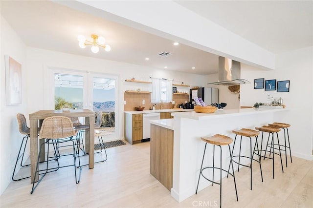 4883 Avenida La Candela, Joshua Tree, CA 92252 - kitchen with range hood, white dishwasher, open shelves, a kitchen bar, and light wood-style floors