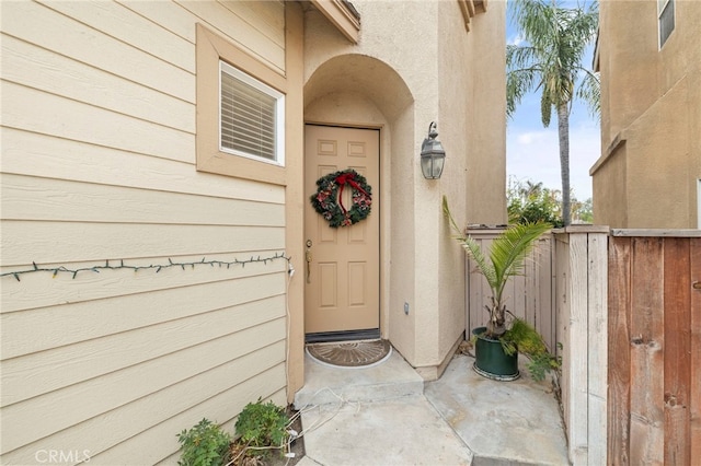 doorway to property featuring fence