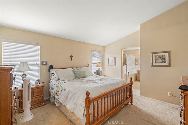 bedroom with light carpet, baseboards, vaulted ceiling, and connected bathroom