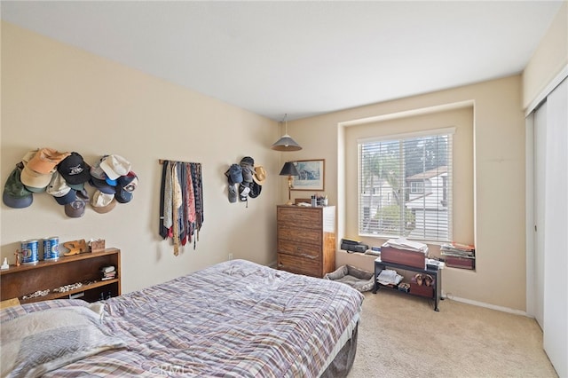 bedroom featuring baseboards and light colored carpet