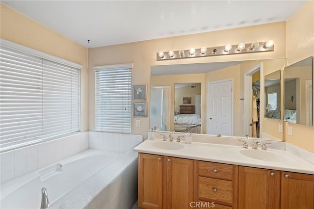 full bath featuring double vanity, a sink, ensuite bath, and a bath