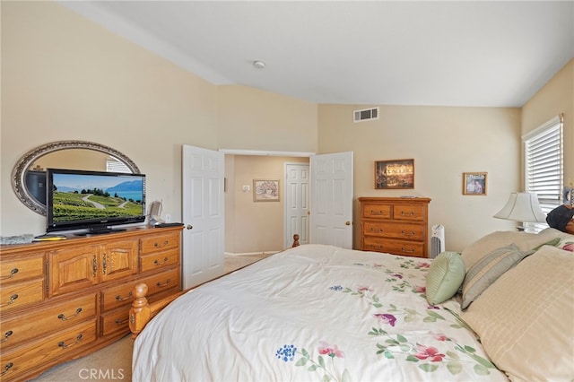 carpeted bedroom featuring lofted ceiling and visible vents