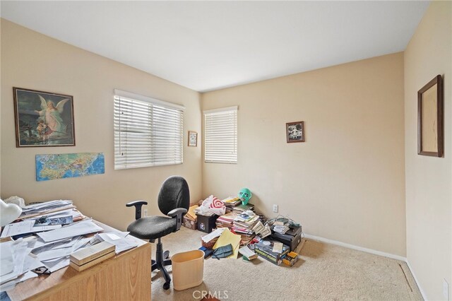 carpeted office featuring baseboards