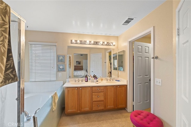 bathroom featuring double vanity, visible vents, connected bathroom, a garden tub, and a sink