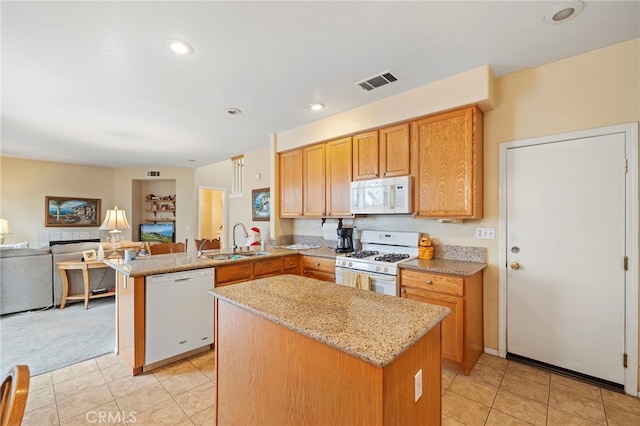 kitchen with visible vents, open floor plan, a sink, white appliances, and a peninsula