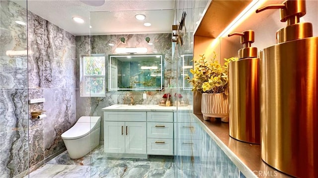 full bath with toilet, marble finish floor, a textured ceiling, vanity, and tile walls