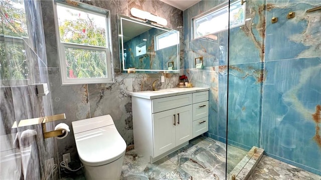 bathroom with marble finish floor, plenty of natural light, tile walls, and vanity