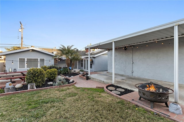 view of yard featuring a patio and an outdoor fire pit