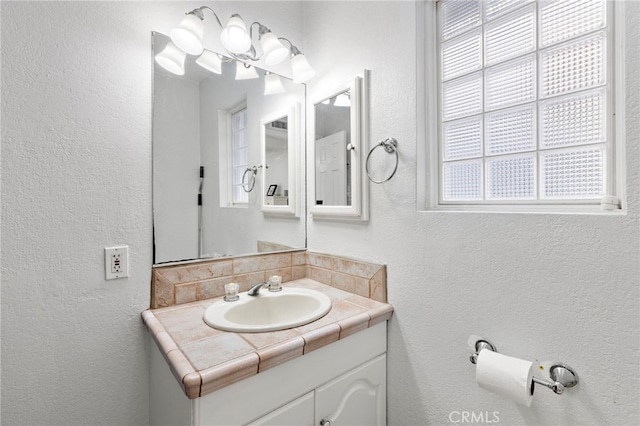 bathroom featuring vanity and a textured wall