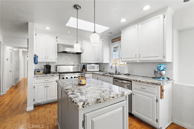 kitchen featuring white microwave, a sink, white cabinets, range with gas cooktop, and wall chimney exhaust hood