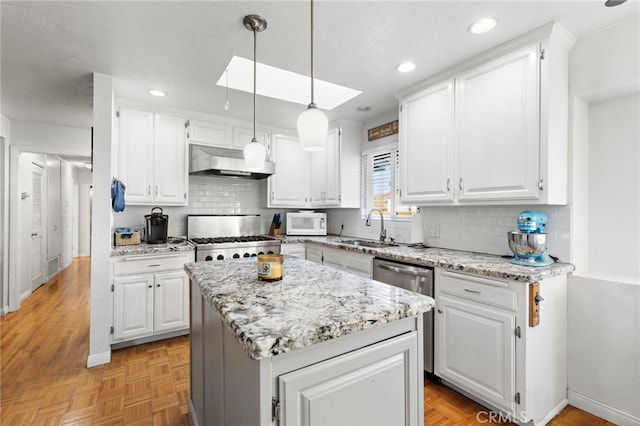 kitchen featuring a sink, wall chimney exhaust hood, white cabinetry, stove, and white microwave
