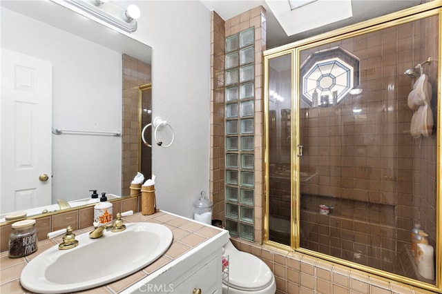 bathroom featuring vanity, toilet, and tiled shower