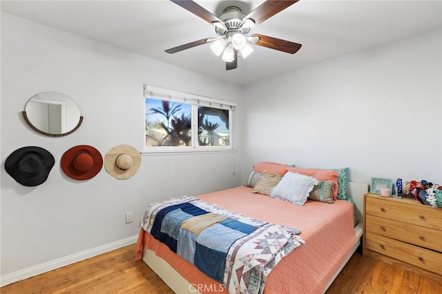 bedroom with a ceiling fan, wood finished floors, and baseboards