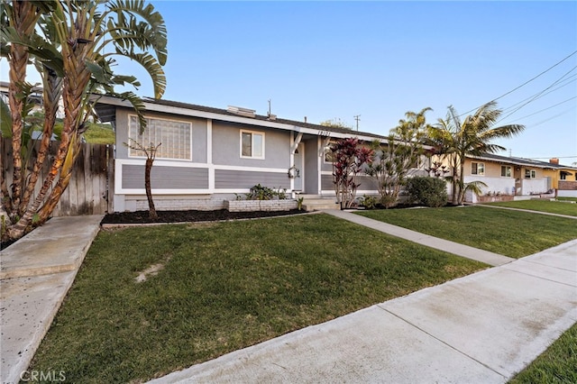 view of front of house with a front yard and fence