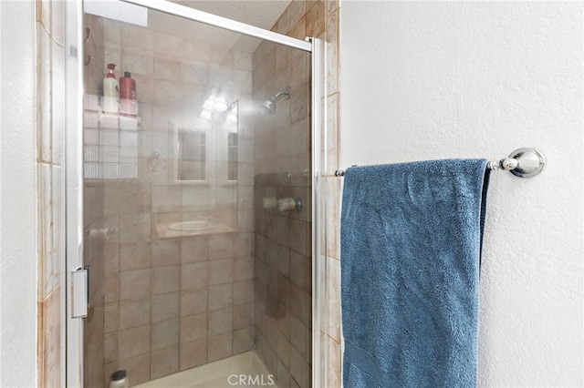 full bath featuring a stall shower and a textured wall