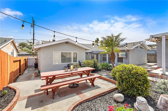 back of property featuring a fenced backyard, a patio, and outdoor dining area