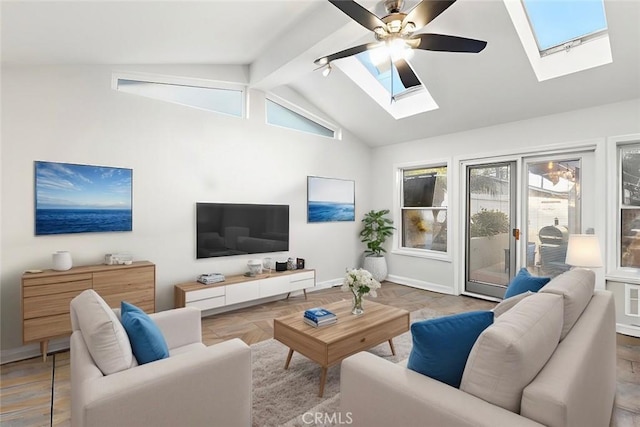 living room with ceiling fan, lofted ceiling with skylight, and baseboards