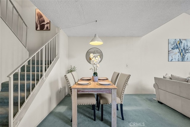 carpeted dining space with a textured ceiling and stairs