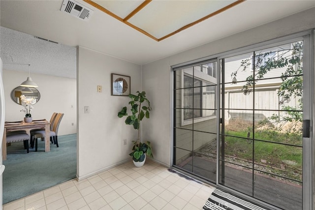 doorway to outside featuring visible vents, light carpet, baseboards, and light tile patterned floors