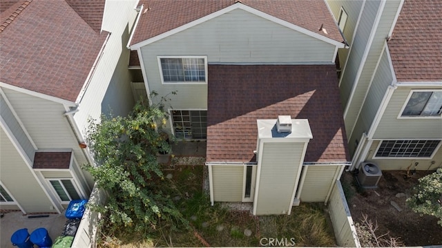 back of property featuring roof with shingles, fence, and central air condition unit