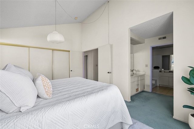 bedroom featuring carpet, a closet, visible vents, a textured ceiling, and ensuite bath