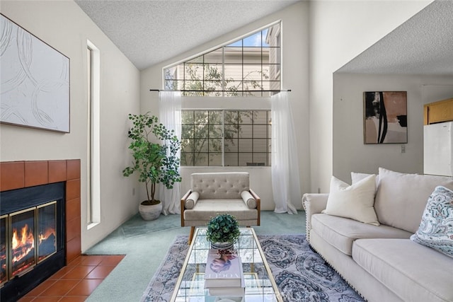 living area featuring lofted ceiling, a tile fireplace, carpet flooring, and a textured ceiling