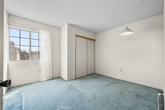 unfurnished bedroom with carpet, a closet, and a textured ceiling