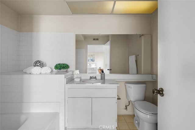 bathroom featuring toilet, vanity, visible vents, tile patterned floors, and a bathtub