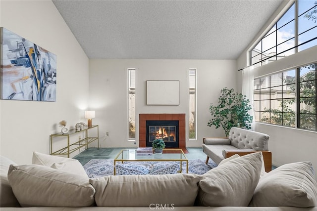 carpeted living area featuring a wealth of natural light, lofted ceiling, and a tiled fireplace