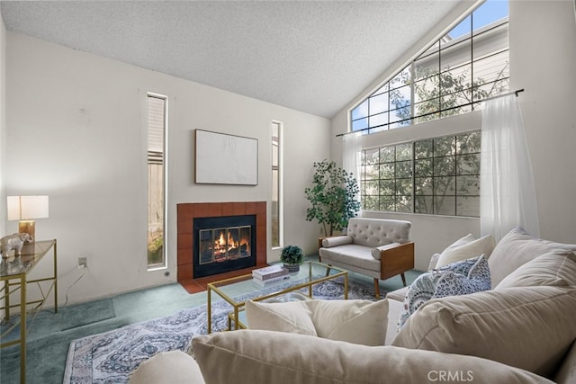 living room featuring a textured ceiling, high vaulted ceiling, a tile fireplace, and carpet flooring