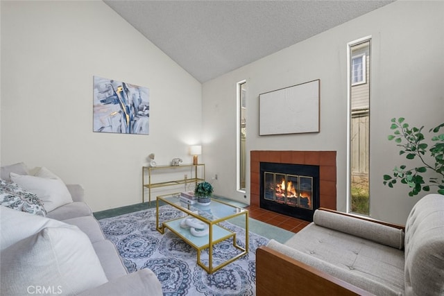 living room with lofted ceiling, a fireplace, and a textured ceiling