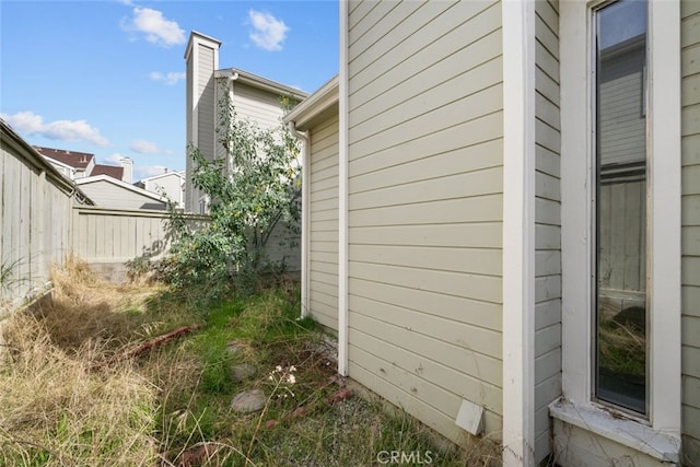 view of side of home featuring fence