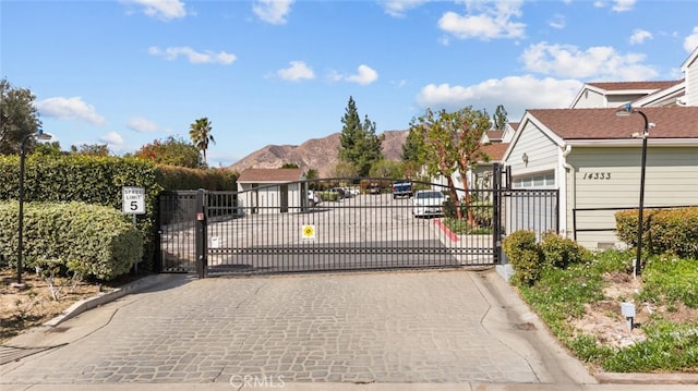 view of gate with fence and a mountain view