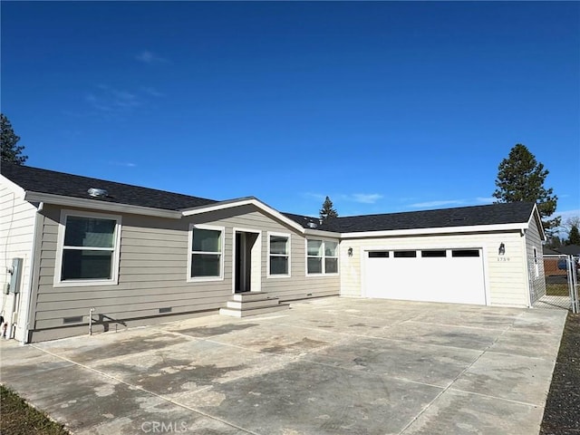 view of front of house featuring entry steps, a shingled roof, concrete driveway, crawl space, and fence