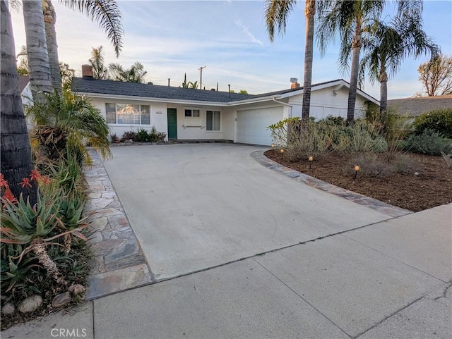 single story home featuring a garage, driveway, a chimney, and stucco siding