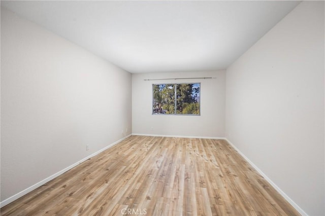 spare room with light wood finished floors and baseboards