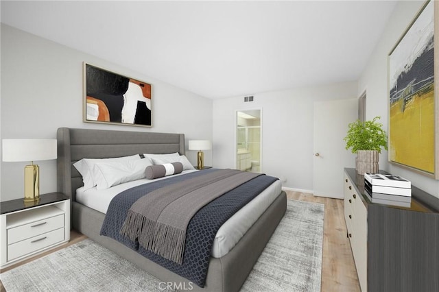 bedroom with visible vents, connected bathroom, and light wood finished floors