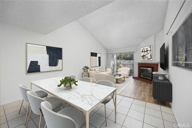 1694 Bridgeport, West Covina, CA 91791 - dining area featuring light tile patterned floors, a textured ceiling, a fireplace, baseboards, and lofted ceiling