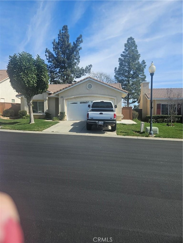 single story home featuring stucco siding, concrete driveway, fence, a garage, and a tiled roof