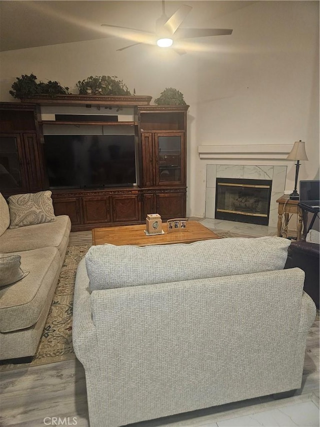 living room featuring ceiling fan and a premium fireplace